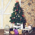 Beautiful Christmas interior design. Home decorated with Christmas tree with gift under the tree, sled and small lamp, toned Royalty Free Stock Photo