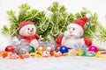 Beautiful Christmas and New Year composition with Santa Claus and snowman in red hats and scarves in front colored toys and in the