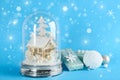 Beautiful Christmas snow globe, gift box and ornaments on light blue background, bokeh effect. Space for text Royalty Free Stock Photo