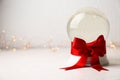 Beautiful Christmas snow globe with red bow on table against light background Royalty Free Stock Photo