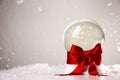 Beautiful Christmas snow globe with red bow on table against light background Royalty Free Stock Photo