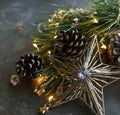 A beautiful Christmas star made of glass and spruce branches with cones are on a dark background. Royalty Free Stock Photo