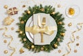 Beautiful Christmas table setting with golden decorations. Plate with gold cutlery in Christmas wreath. New Year party. Top view, Royalty Free Stock Photo