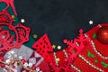 Beautiful Christmas toys on a blackboard, red Christmas decorations, bells, stars, wooden figurines