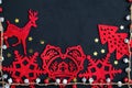 Beautiful Christmas toys on blackboard, red Christmas decorations, bells, stars, wooden figurines