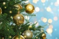 Beautiful Christmas tree with bright baubles against blurred lights on light blue background, closeup. Space for text Royalty Free Stock Photo