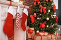 Beautiful Christmas tree and gifts near decorative fireplace Royalty Free Stock Photo