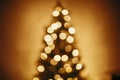 beautiful christmas tree golden lights in festive room. christmas abstract background, blur defocused bokeh of yellow glowing de