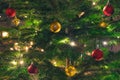 Beautiful Christmas tree with ornaments, yellow warm lights and golden and red balls Royalty Free Stock Photo
