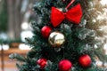 Beautiful Christmas tree with red and gold balls and big bows close-up in the park on a sunny winter day. Royalty Free Stock Photo