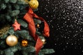 Beautiful Christmas tree with red and golden decor against black blurred shiny glossy background. New Year and Christmas Royalty Free Stock Photo