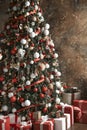 Beautiful Christmas tree with red and white decor. Gifts under tree. New Year`s tinsel. Festive interior design Royalty Free Stock Photo