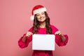 Beautiful Christmas woman in Santa hat holding blank empty paper banner board on pink background, Xmas portrait Royalty Free Stock Photo