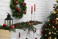 Beautiful Christmas wreath hanging over fireplace indoors