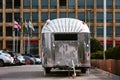 Beautiful chrome vintage motorhome or travel trailer in the hotel parking lot in the city