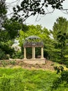 Circular garden gazebo with white pillars and black rounded roof