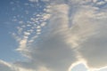 Beautiful cirrus and cumulus clouds on a bright blue sky lit by sunlight