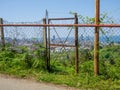 A beautiful city behind an old fence. Abandoned structure. Rusty metal. View from the mountain to the modern city. Beautiful