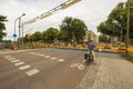 Beautiful city landscape view on summer day. People and cars on red stop light of railroad crossing awaiting of coming speed train Royalty Free Stock Photo