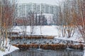 Beautiful city park on the outskirts of the city. Winter, gloomy sky and heavy snow. Ducks hibernate in an unfrozen stream Royalty Free Stock Photo