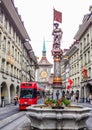 Beautiful City Street View of the colorful medieval Marksman statue on top of elaborate fountain in Bern, Switzerland.