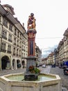 Beautiful City Street View of the colorful medieval Samson statue on top of elaborate fountain in Bern, Switzerland. The fountain