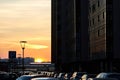 Beautiful city sunset. Evening photo of Parking space in a small town. Reflection of sun in Windows of three-storey building Royalty Free Stock Photo