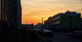 Beautiful city sunset. Evening photo of Parking space in a small town. Reflection of sun in Windows of three-storey building Royalty Free Stock Photo