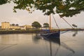 Beautiful cityscape scenery with old wooden fishing boat named Galway hooker in the Corrib River with colorful houses in the back Royalty Free Stock Photo