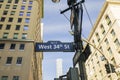 Beautiful cityscape view of buildings tops on blue sky background. Sign of West 34th Street. New York.