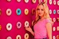 Beautiful clamour blonde girl in pink closeup on the pink donut background Royalty Free Stock Photo