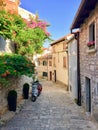 A beautiful classic narrow cobblestone European street with colourful flowers and a motorcycle parked. Royalty Free Stock Photo