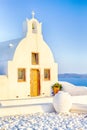 Beautiful Classic White Roofed Church With Flat Pediment and Bell Against Volcanic Caldera on Oia Island in Santorini in Greece