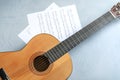 Beautiful classical guitar and music sheets on color background Royalty Free Stock Photo