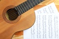 Beautiful classical guitar and music sheets on wooden background Royalty Free Stock Photo