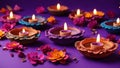 Beautiful clay Diya lamps with flowers on a dark purple background. Exquisite Diya\'s for Diwali decoration