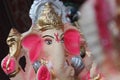 A Beautiful clay statue/Idol of an Indian god Lord Ganesha decorated with colorful drapery and Marigold garland