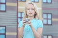 Beautiful and clever blonde kid girl solves a mirror cube puzzle Royalty Free Stock Photo