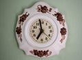 Beautiful porcelain white vintage clock hanging on the pastel wall