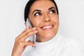 Beautiful close-up portrait of attractive young dream woman with mobile phone with pretty toothy smile, on the white background Royalty Free Stock Photo