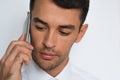 Beautiful close-up portrait of young man using mobile phone on gray background. Businessman speaking on his smart phone. Royalty Free Stock Photo