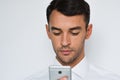 Beautiful close-up portrait of young man using mobile phone on gray background. Businessman speaking on his smart phone. Royalty Free Stock Photo