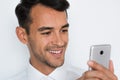 Beautiful close-up portrait of young man using mobile phone on gray background. Businessman speaking on his smart phone. Royalty Free Stock Photo