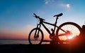 Beautiful close up scene of bicycle at sunset, sun on blue sky with vintage colors, silhouette of bike forward to sun