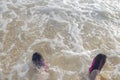 Beautiful close up view of foam wave on men`s feet in swimming shoes. Royalty Free Stock Photo