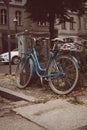 Beautiful closeup of a blue bicycle leaning on a bicycle stand