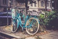 Beautiful closeup of a blue bicycle leaning on a bicycle stand near a power box