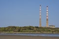 Beautiful closeup bright view of iconic Poolbeg CCGT station chimneys against clear blue sky seen from Sandymount Beach Royalty Free Stock Photo