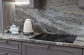 beautiful closeup of custom designed kitchen, with marble looking quartz countertop and backsplash. cream electric Royalty Free Stock Photo