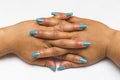 Beautiful closeup of hands of a young woman with long Blue manicure on nails.1